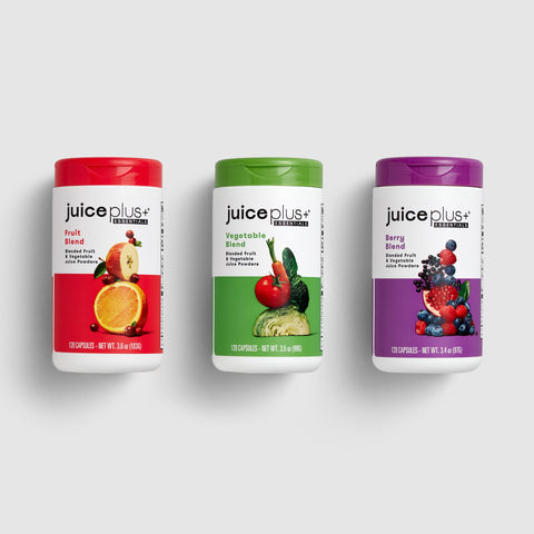 Three 'Juice Plus+' supplement containers on a white background