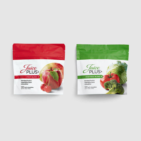 Two packages of Juice Plus+ Chewables on a white background, one with an apple and the other with vegetables.