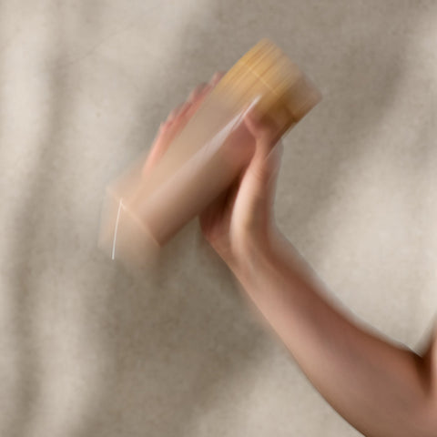 Person holding a shake against a neutral background