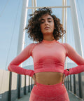Woman in a pink athletic outfit standing on a bridge