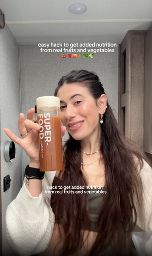 Person holding a SuperFood drink container with text overlay about added nutrition from real fruits and vegetables.