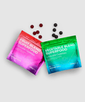 Two packets of juiceplus+ gummies, one pink and one green, with scattered gummies on a light gray background.